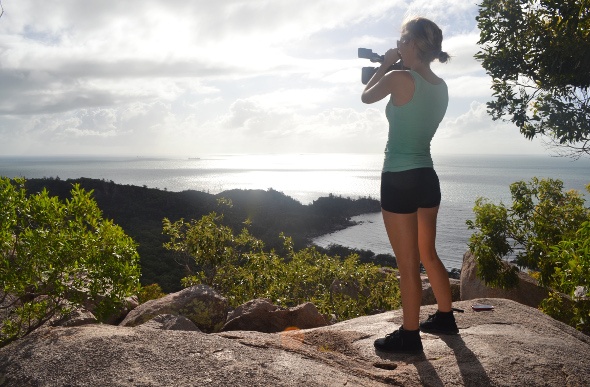 Lady filming the scenery from the edge of the cliff