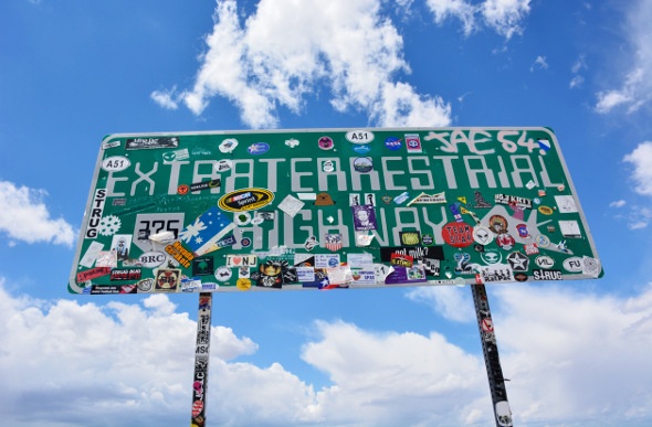  Extraterrestrial Highway sign with a lot of stickers on it