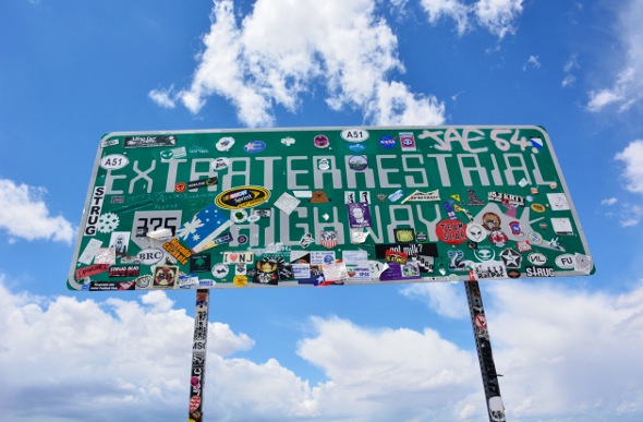 Extraterrestrial Highway sign with a lot of stickers on it