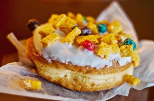  A round doughnut with white cream and colorful toppings 