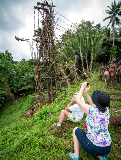 A Vanuatu local jumping from a wooden tower with vines around his ankles