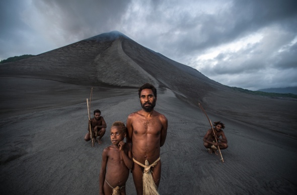 Four locals with spears standing in front of My Yasur on Tanna