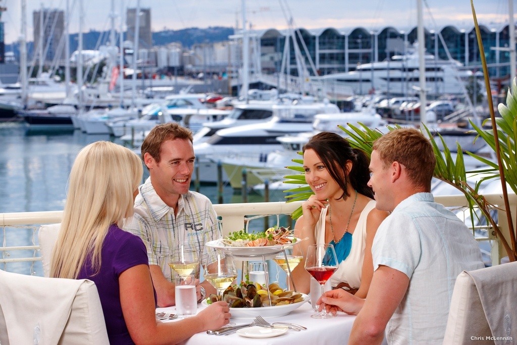  Group of friends happily sharing a meal together in a restaurant in the Viaduct Harbour