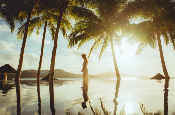 A young woman is reflected in the infinity-edge pool at the Beach Club on Hamilton Island.