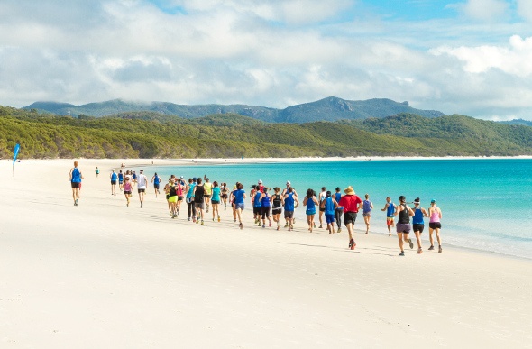People running along the shore of Whitehaven Beach