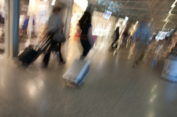 people pulling their suitcases aa they rush through the airport 