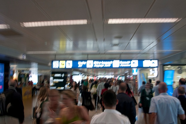Crowds of people moving through an airport