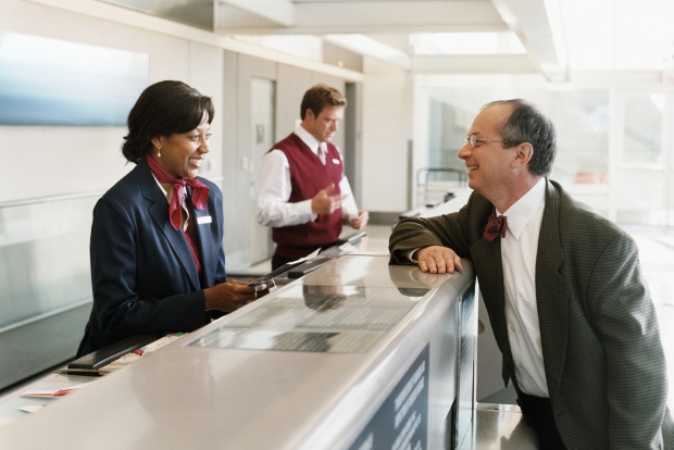 A man talking to a customer service agent at the airport