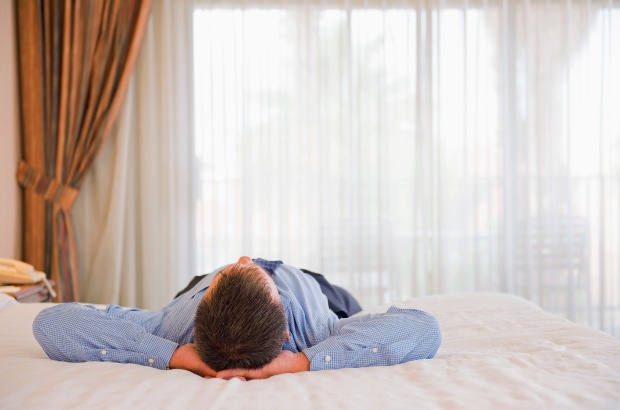Man laying on hotel bed