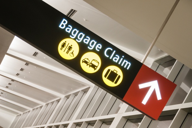 An airport sign pointing to the baggage claim area