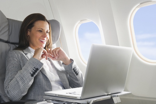 Woman using her laptop in an airplane 
