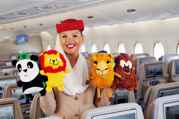 Emirates flight attendant holding children's stuffed toys 