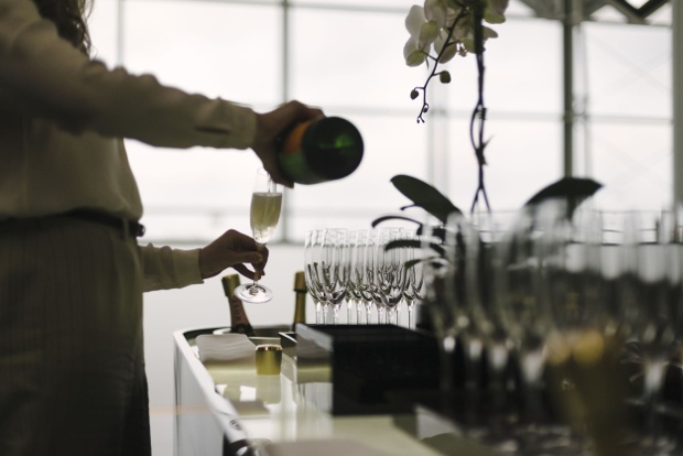 A woman pours herself a glass of champagne in one of Cathay Pacific's lounges.