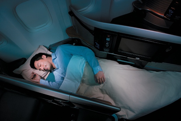 A man sleeping in one of Cathay Pacific's lie-flat business class seats
