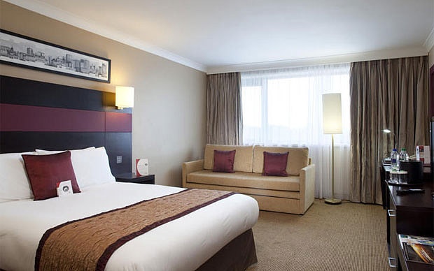 Hotel room with bed and brown couch