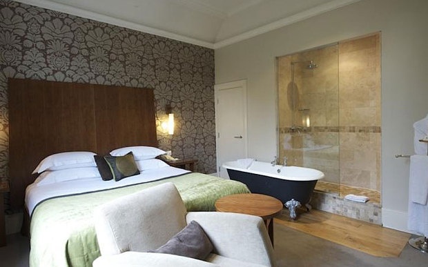 Hotel room with wooden bedhead and black bath 