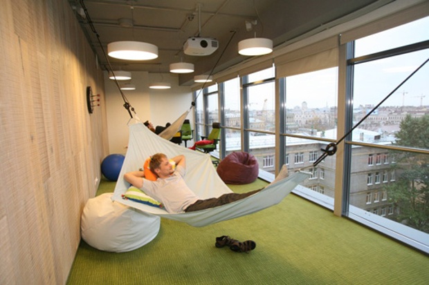 One of the offices in google with employees laying on hammocks and enjoying the city views