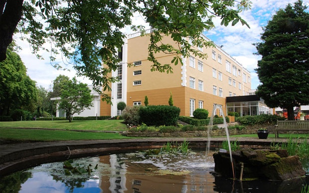 Outdoor pond next to large orange building 