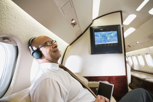 guy enjoying his flight on an airplane listening to music