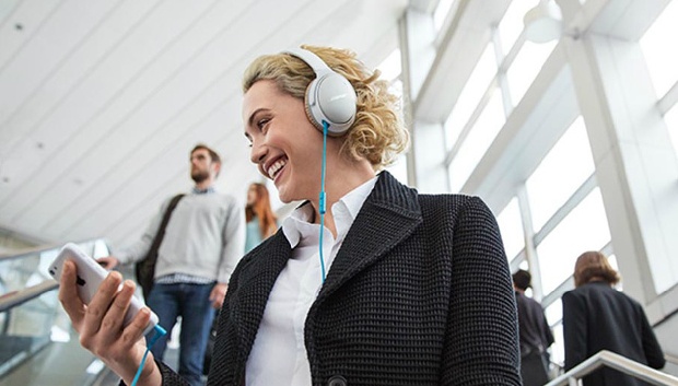 Lady listening to music using a gray BOSE headphones