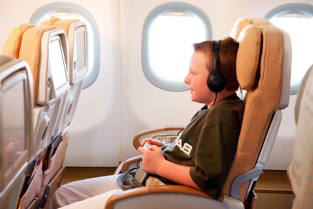 A young passenger playing video games with his in-flight entertainment system