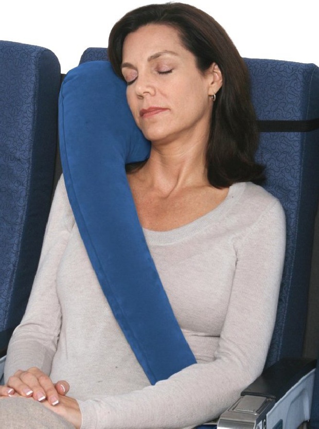 Woman asleep in a chair with a blue travel pillow on her shoulder