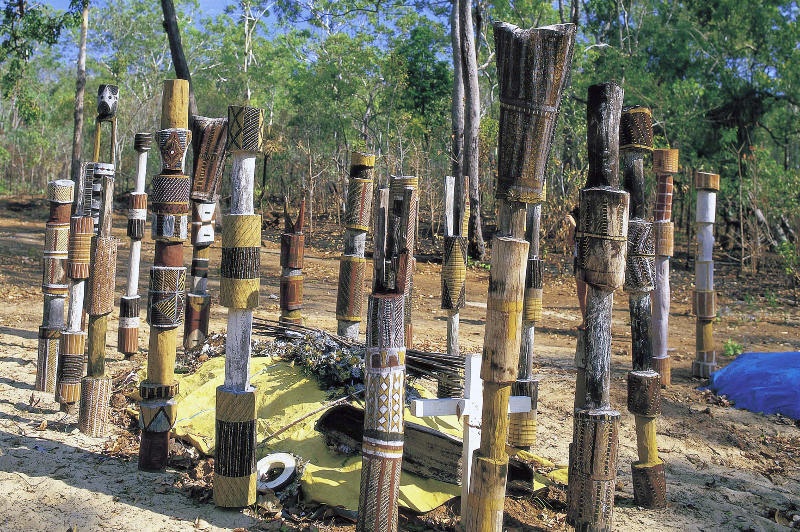 Aboriginal art adorns poles surrounding a burial site on Melville Island in the Tiwi Islands.