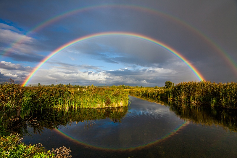 A double rainbow over a river in Hawaii