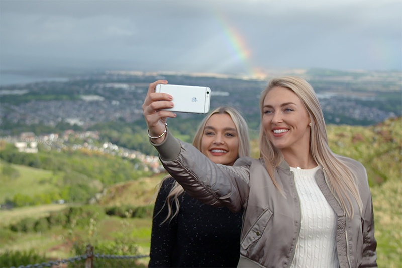 Two women take a selfie at Arthur's Seat, Edinburgh.