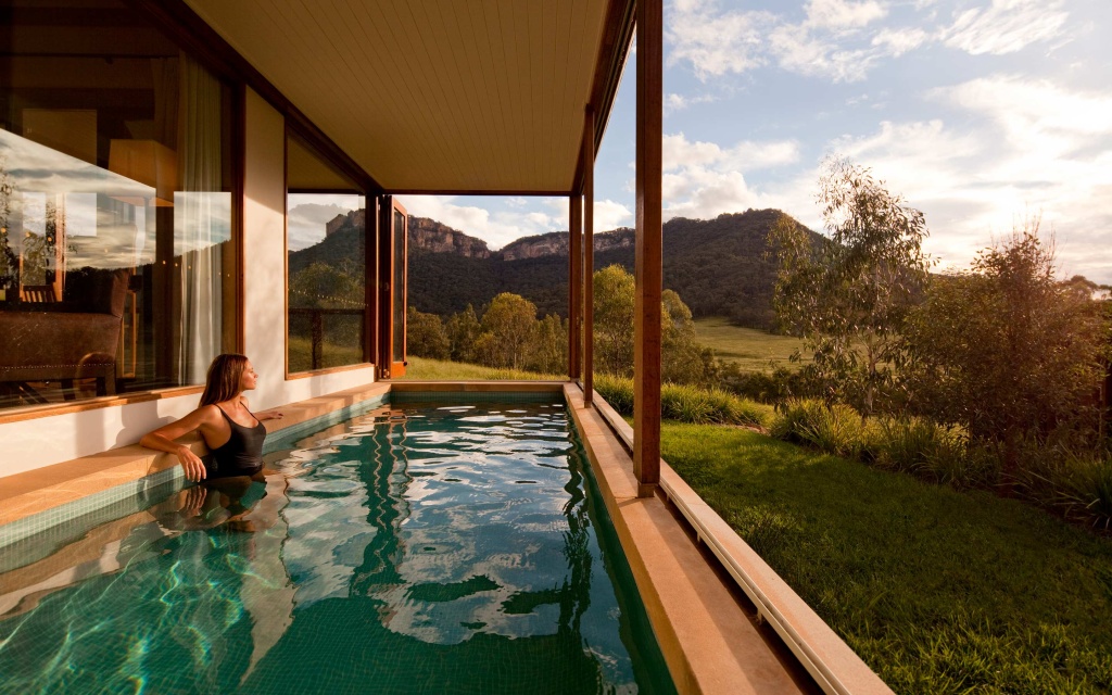 Woman admiring the scenic view from the heritage villa swimming pool