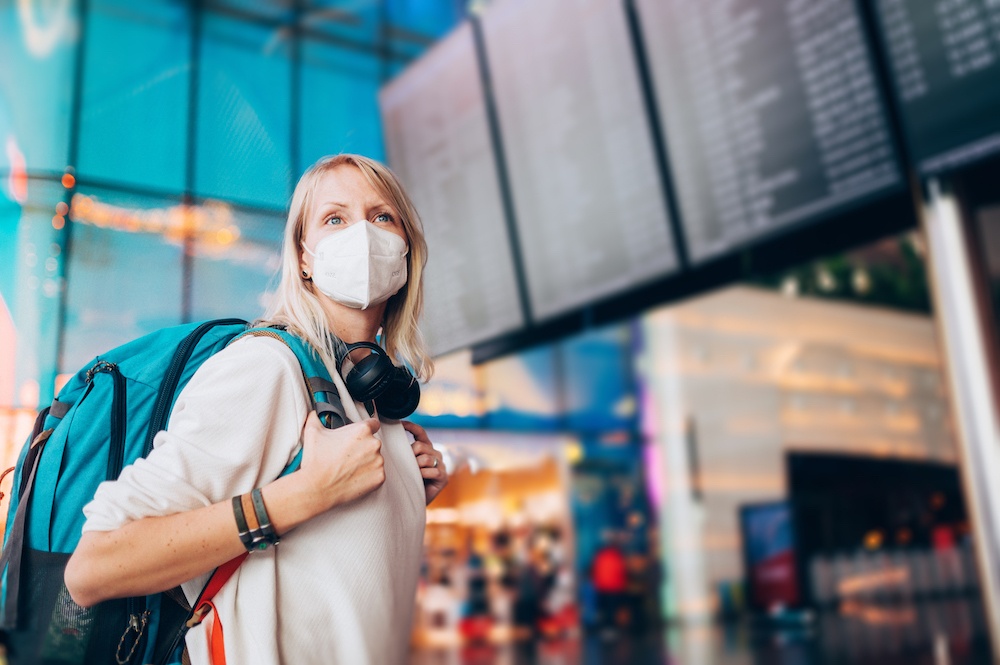 Woman wearing backpack and headphones in the airport 