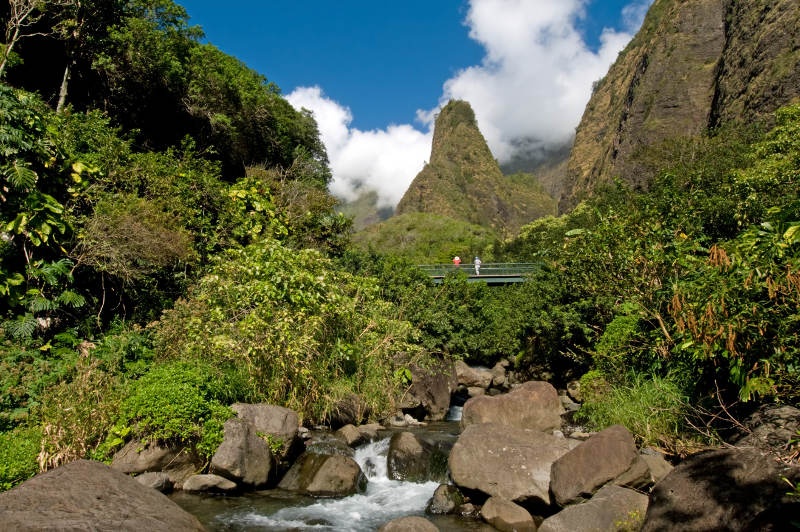 Two tourists enjoying the view of mountains in a bridge