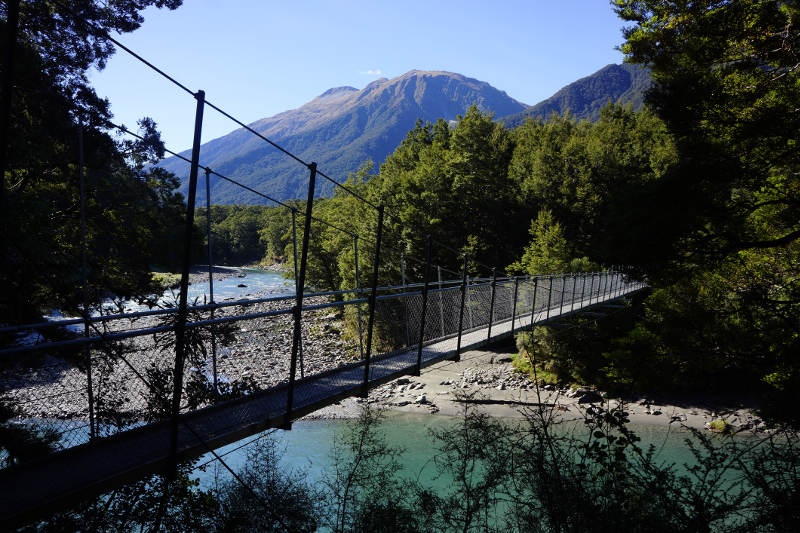 Swing bridge over river showing a mountain on the background