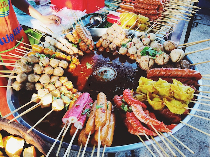 a selection of street food on a burner in a Thai market