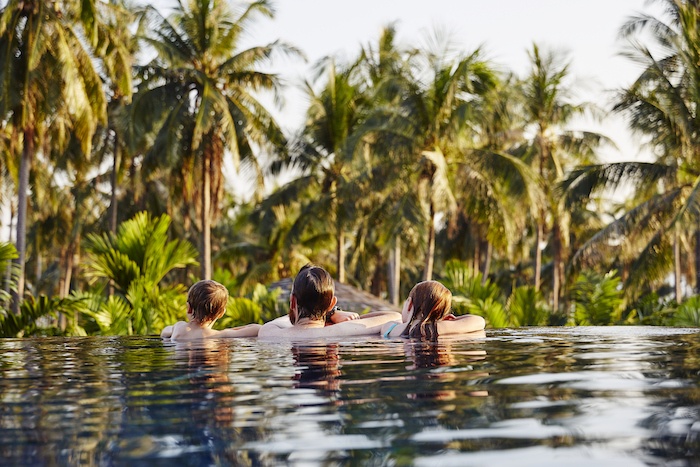 family relaxing in a pool in Thailand