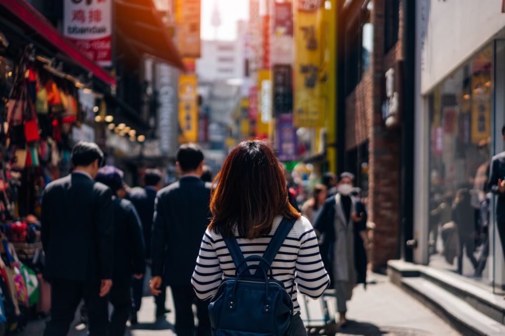 Lady in a backpack walking towards the busy market