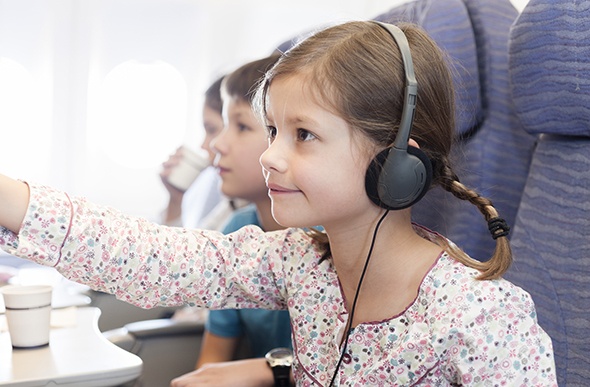 girl in a plane seat wearing headphones 