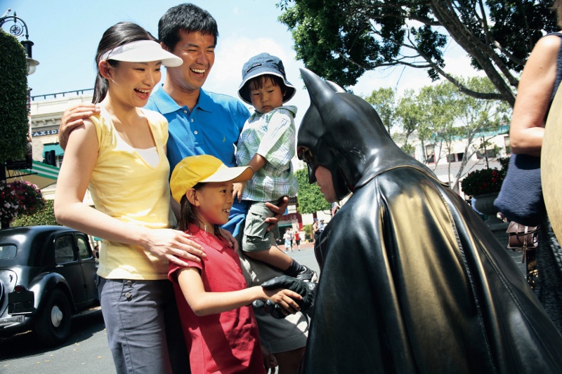Batman character shakes hand of child with family at Movieworld on the Gold Coast.