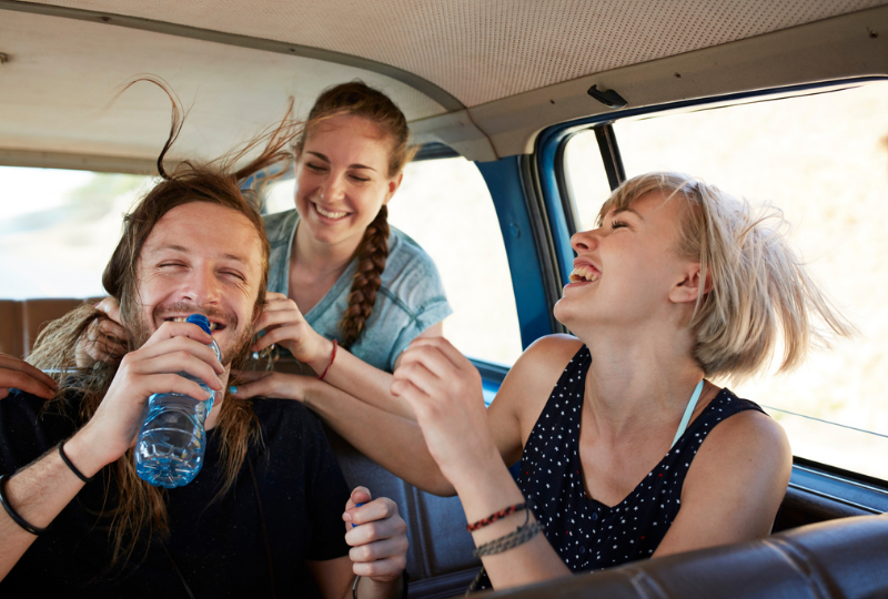 Friends sharing water in the car 