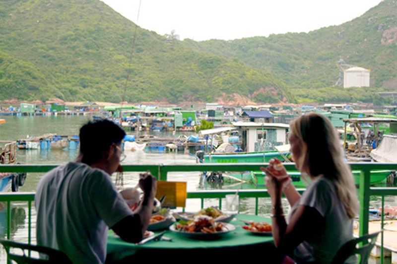 Two people eat a seafood lunch on a floating restaurant on Lamma Island, Hong Kong.
