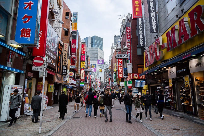 man walking down busy street in shibuya tokyo