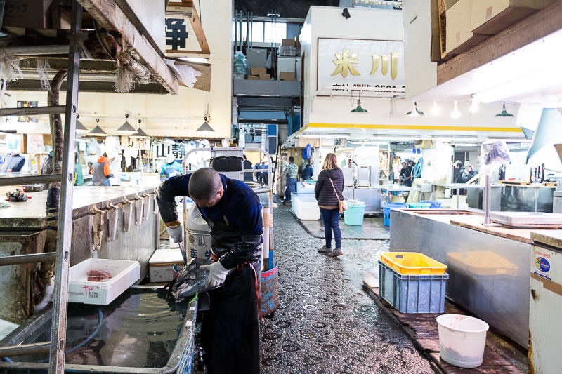 Fish vendor working on a fish in a Japanese wet market