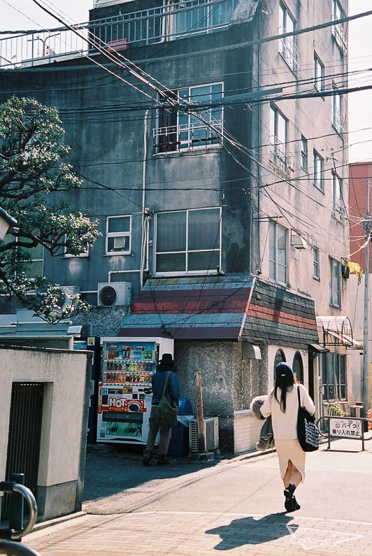 woman walking into sunshine in tokyo street