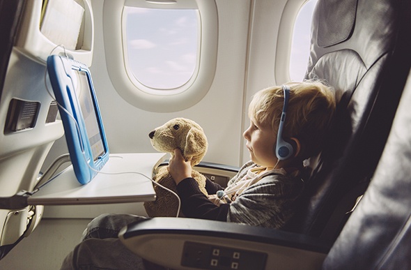 boy watching videos on his tablet with stuffed toy 