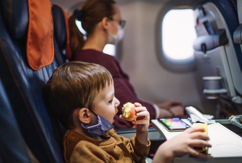 Image of a young kid eating on a plane