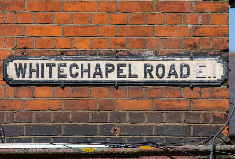 Whitechapel Road signage attached on a red brick wall