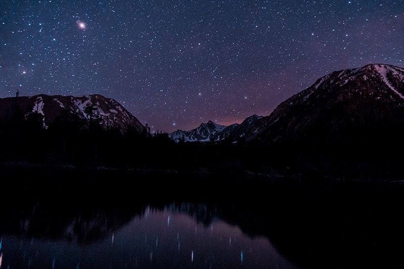 A starry night sky over Sherwin Lakes, California