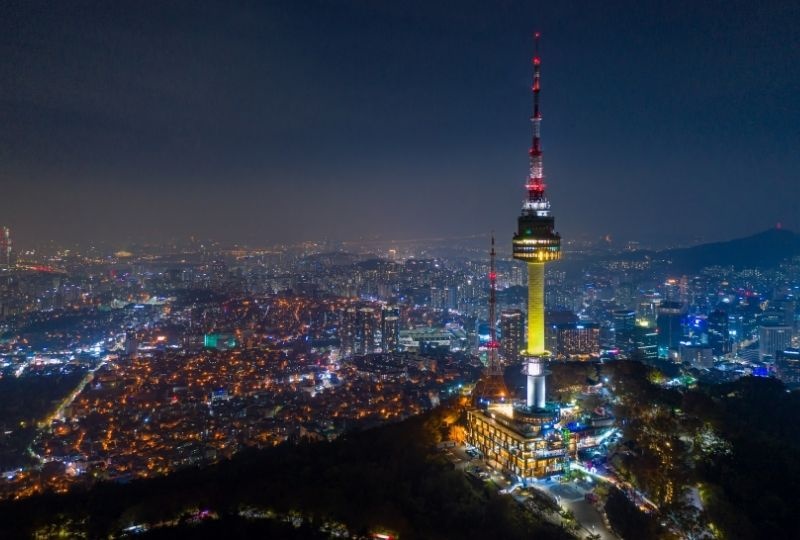 Namsan Seoul Tower lit up at night surrounded by city lights 