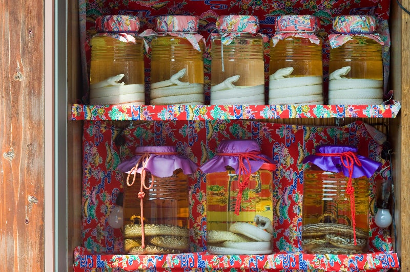Rows of jars containing the liquor awamori and a snake in Okinawa, Japan.