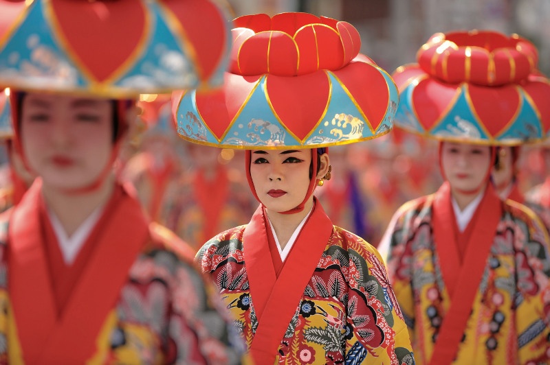 A woman wears a traditional bingata kimono and lotus-flower headpiece for a festival performance. Image: Getty